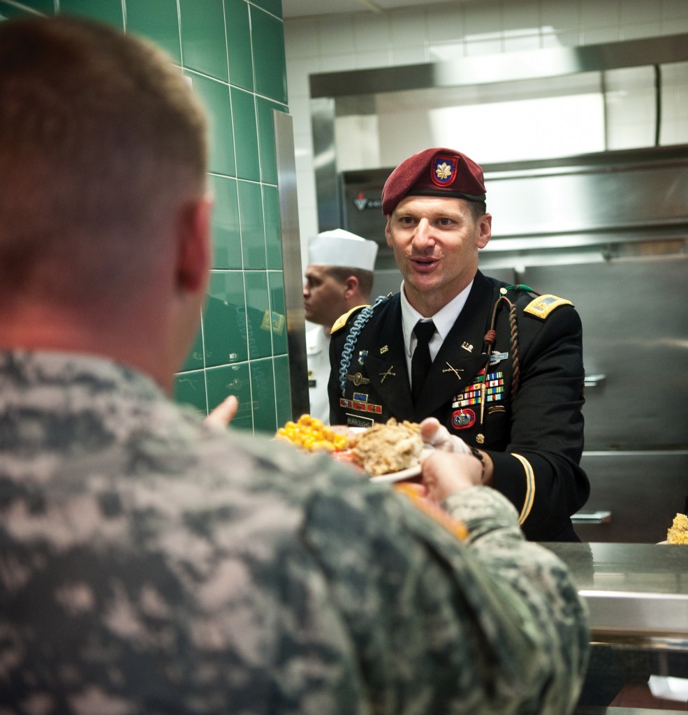 Fort Bragg holds its annual Thanksgiving meal on Wednesday. Officers, such as Maj. Jeff Burroughs, go behind the counter to pile fixings high atop the troops' plates.