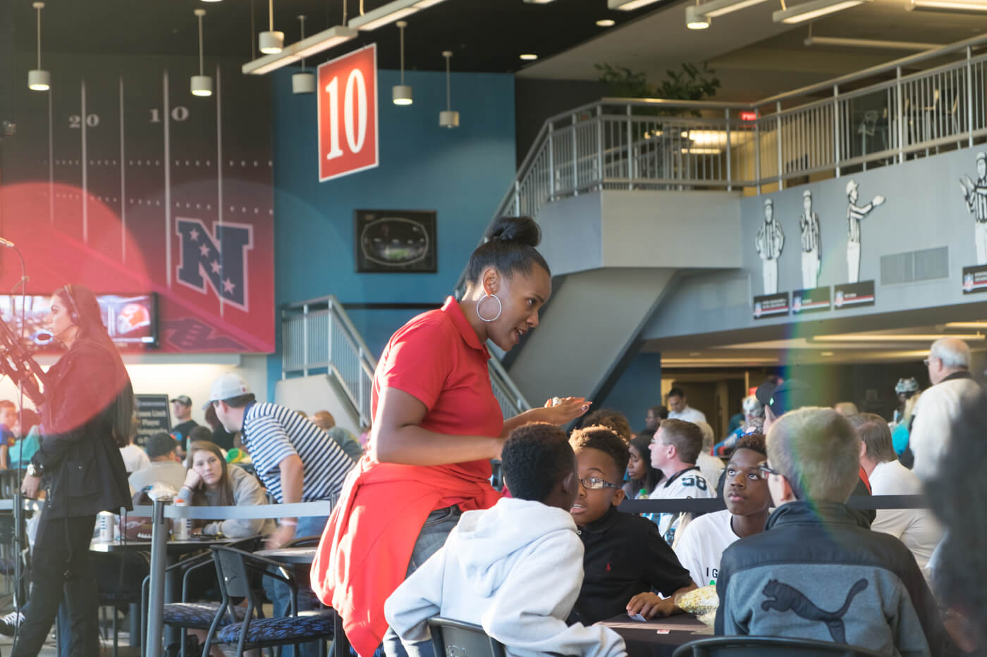 Kelly Davis interacts with academy students while Thomas Davis signs autographs nearby.