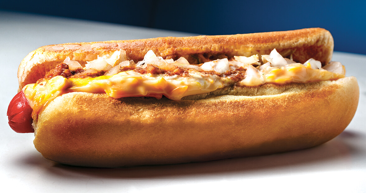 Hot dog topped with chili, cheese, and onions.