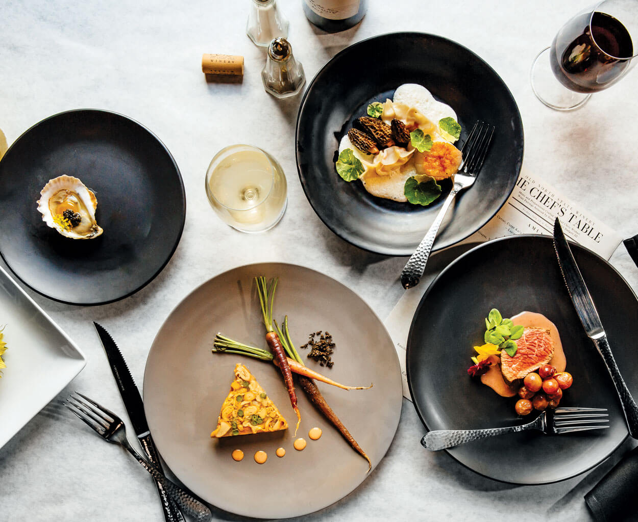 Clockwise from left: Harkers Island oyster; lobster dumplings with sea scallop, morels, and nasturtiums; shoulder tender, roasted grapes, grape puree, and pea shoots; terrine of foraged chanterelles, haricots verts, and fennel.