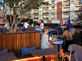 Assorted people eating on roof dining area of Lincoln Street Kitchen.