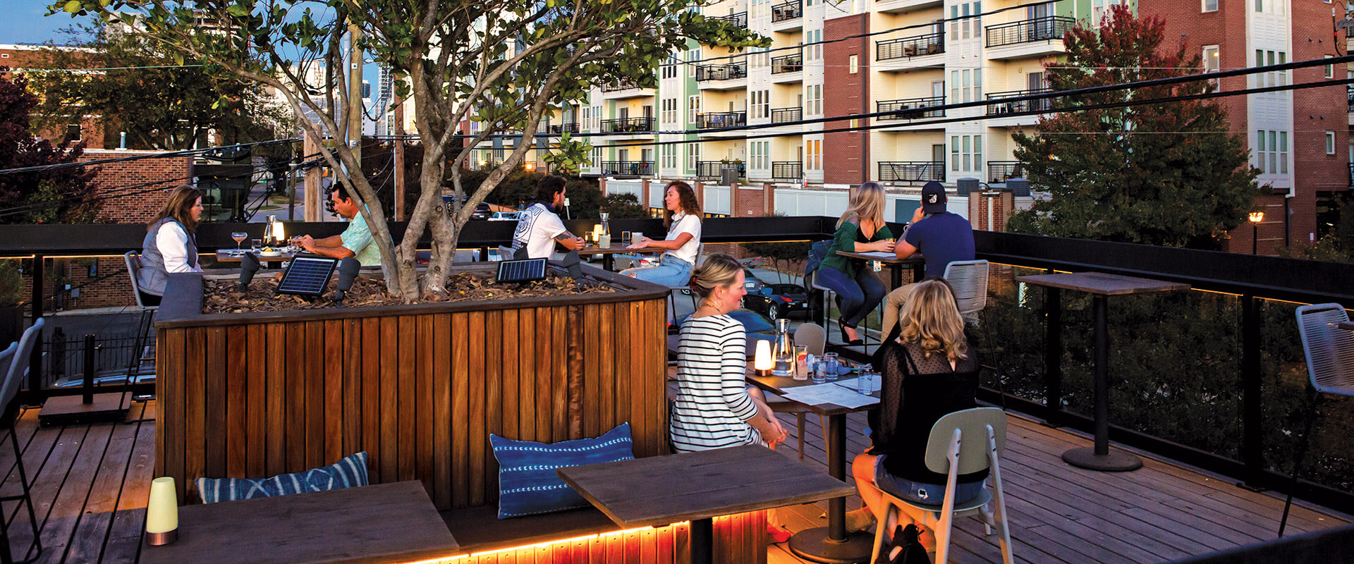 Assorted people eating on roof dining area of Lincoln Street Kitchen.