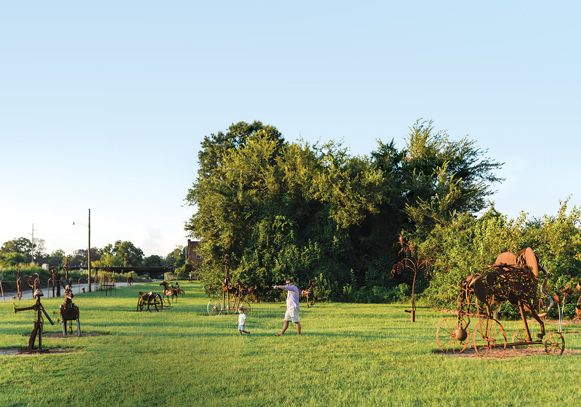 Father and child wander from sculpture to sculpture.