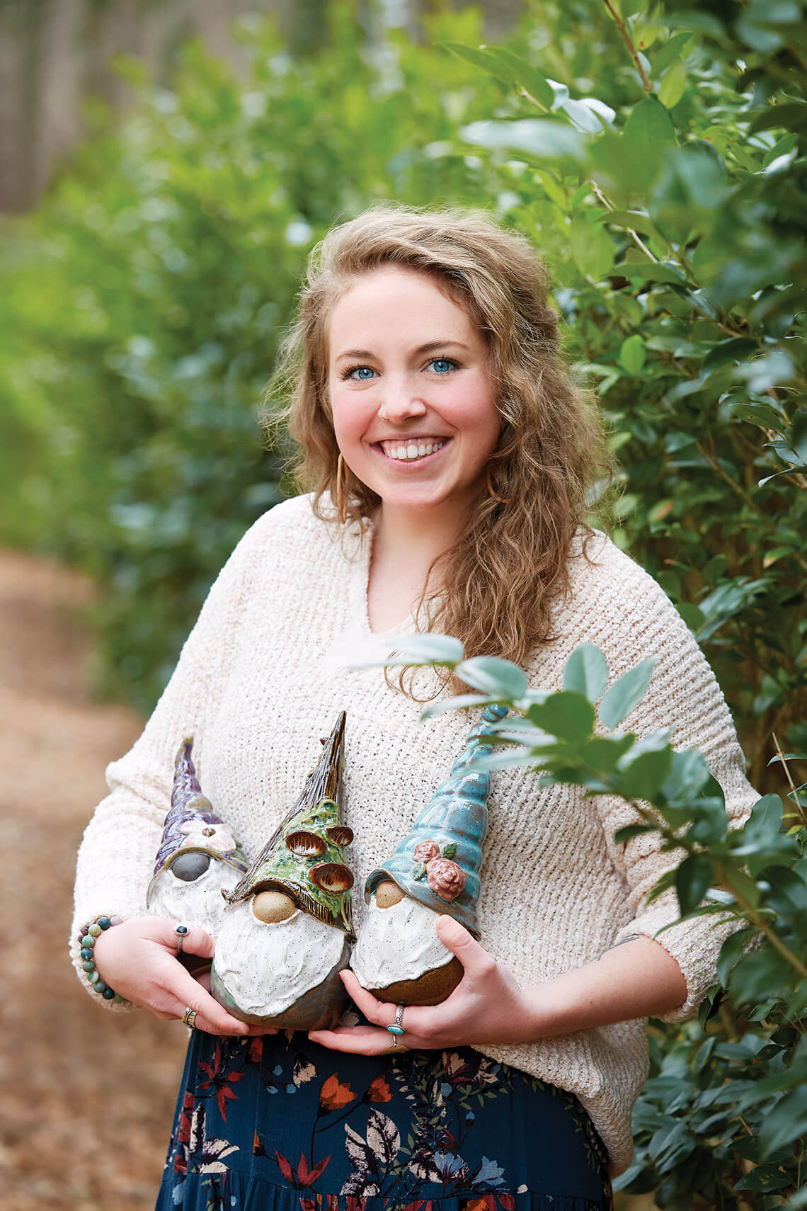 Morgan Greenhaw holds three of her garden gnome creations.