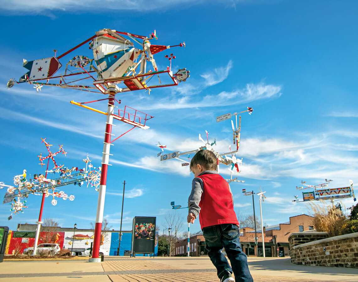 Children play beneath the whirligig Time Machine.
