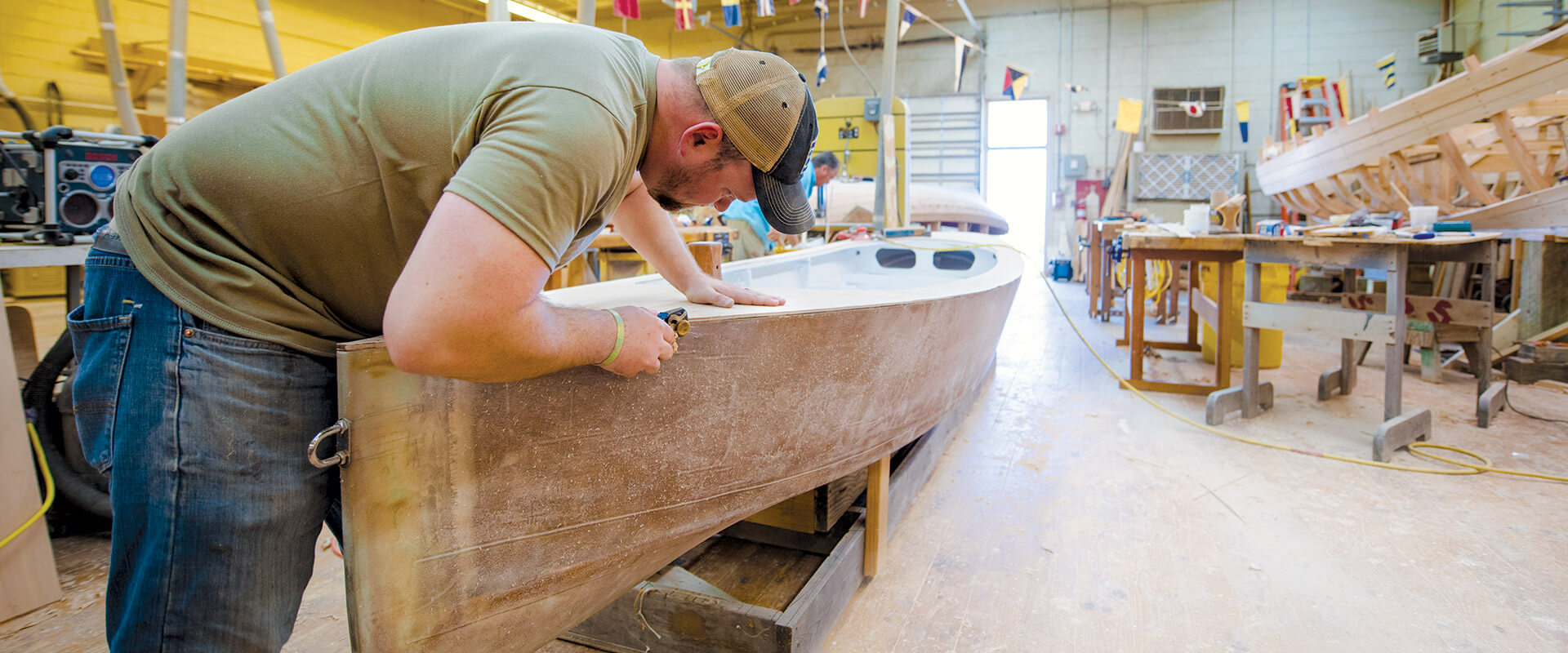 Student uses planer to shape boat trim.