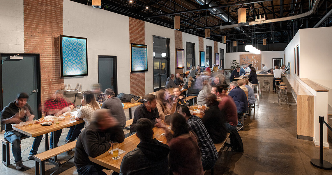 Patrons sit at the long tables at Radar Brewing, a Winston-Salem brewery.