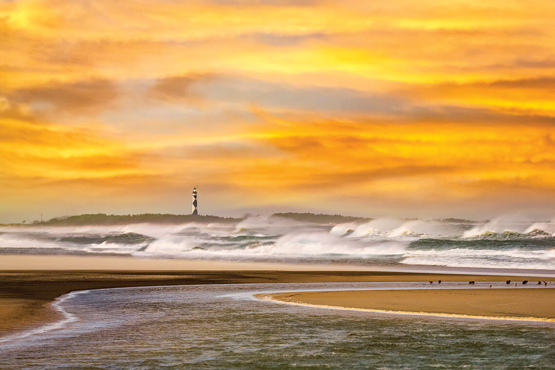 Cape Lookout Lighthouse across the ocean from Cape Point along the Outer Banks barrier islands.
