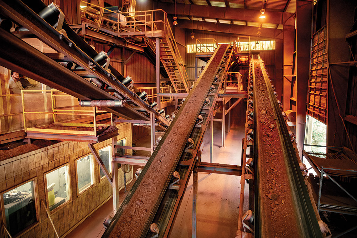 Red clay rides a conveyor belt inside the Lee Brick and Tile factory.
