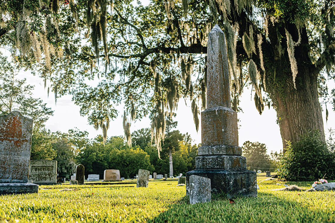 Tombstones underneath a live oak tree at Greenwood Cemetery, one of the North Carolina cemeteries.