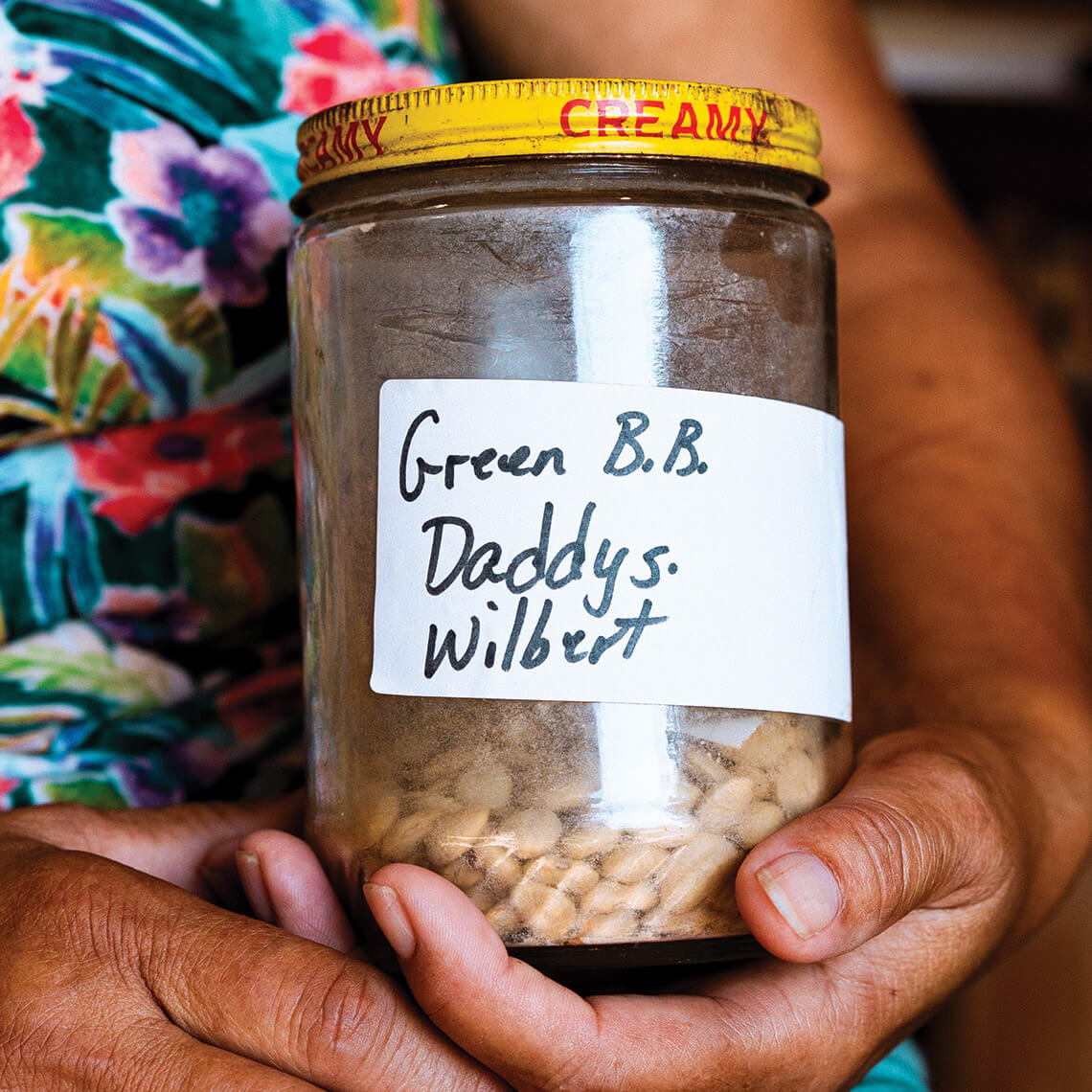 Connie Locklear holds jar of green bean seeds she collected from her late father.