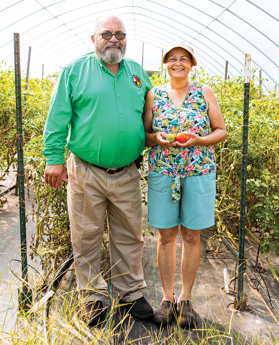 Connie and Millard Locklear pose with tomato vines at New Ground Farm