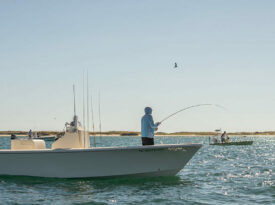 Man fishes off of a boat