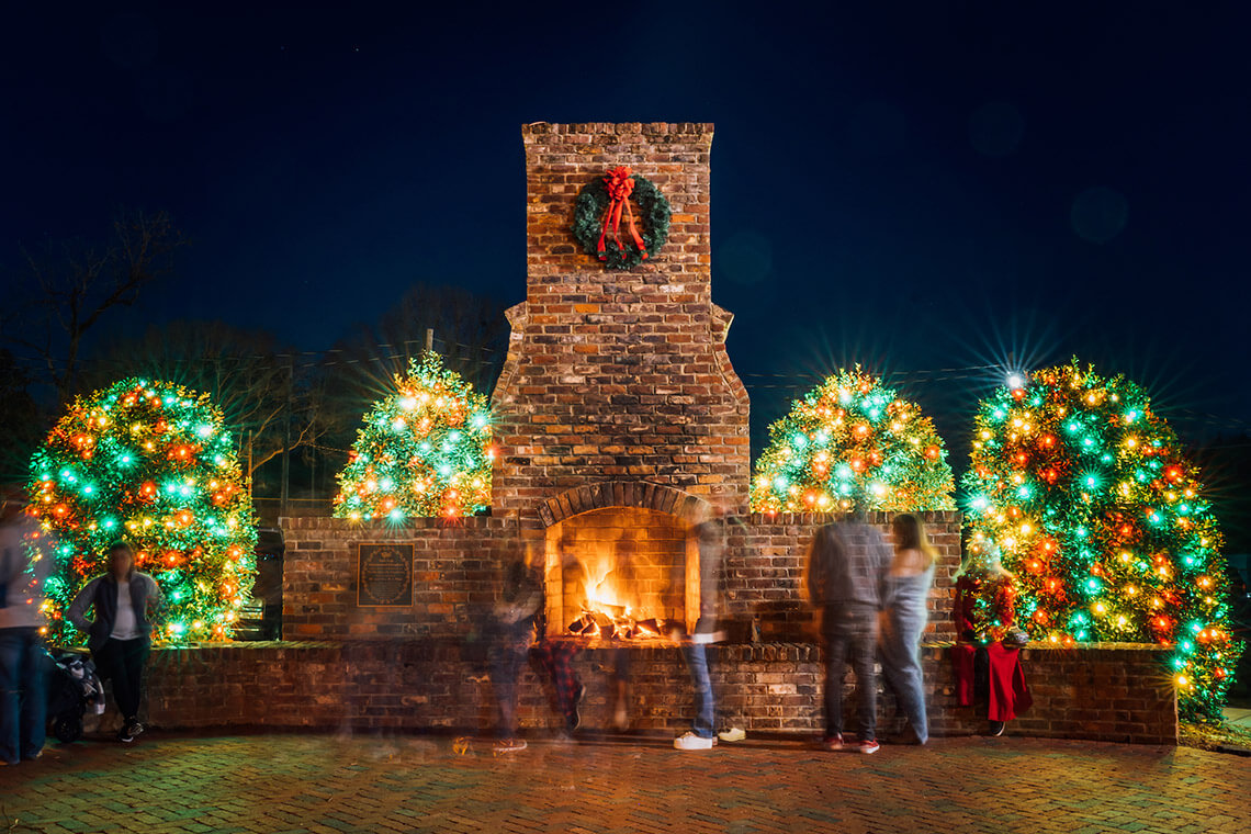Decorated trees next to a wood-burning hearth at Christmas Town USA in McAdenville