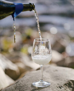 A bottle pours a glass of North Carolina wine.