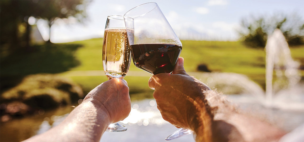 Two people toast their glasses filled with a North Carolina wine.