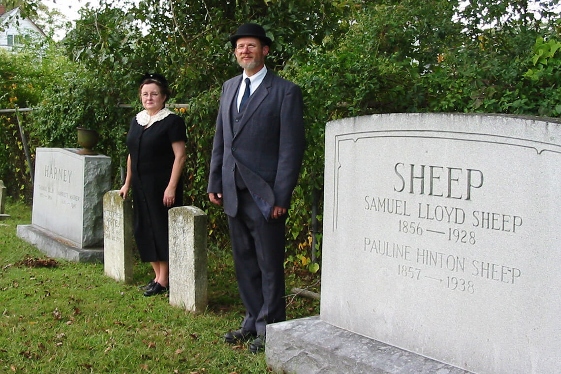 Reenactors pose next to gravestones