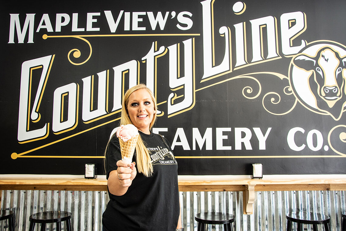 Woman holds ice cream cone at Maple View's County Line Creamery 