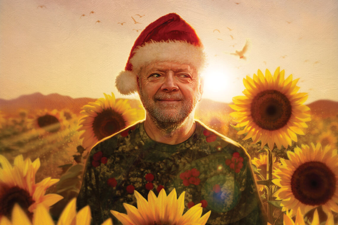 Man wearing Santa hat in a field of sunflowers