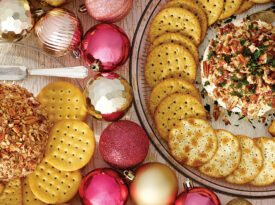 Table with 2 cheese balls surrounded with crackers and ornaments.