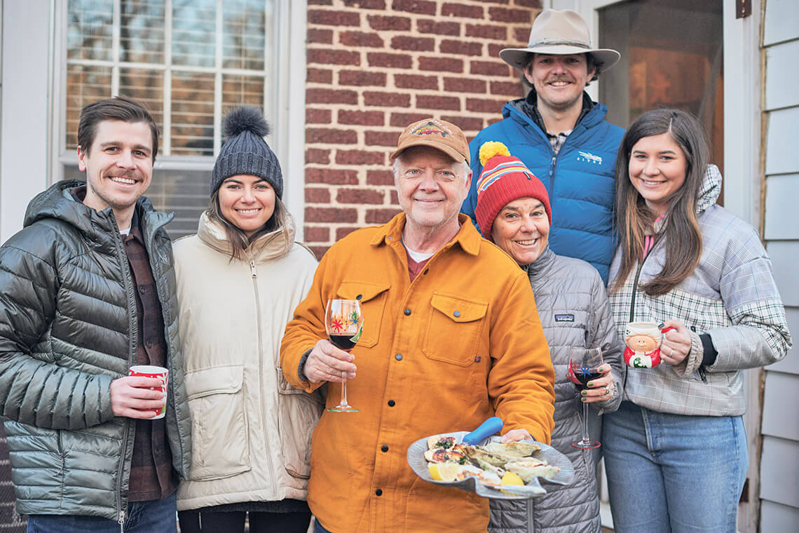 Author T. Edwards Nickens, surrounded by family members, holds a plate of oysters