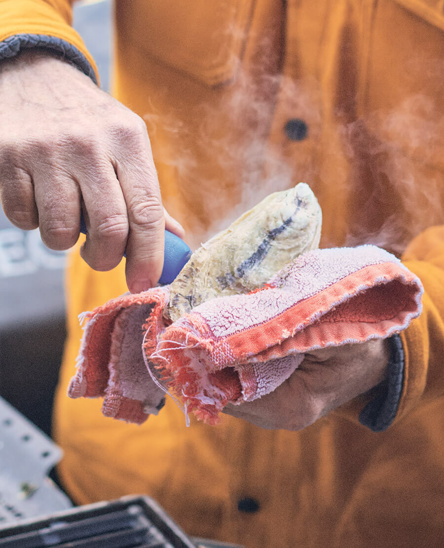 Shucking a steaming hot roasted oyster