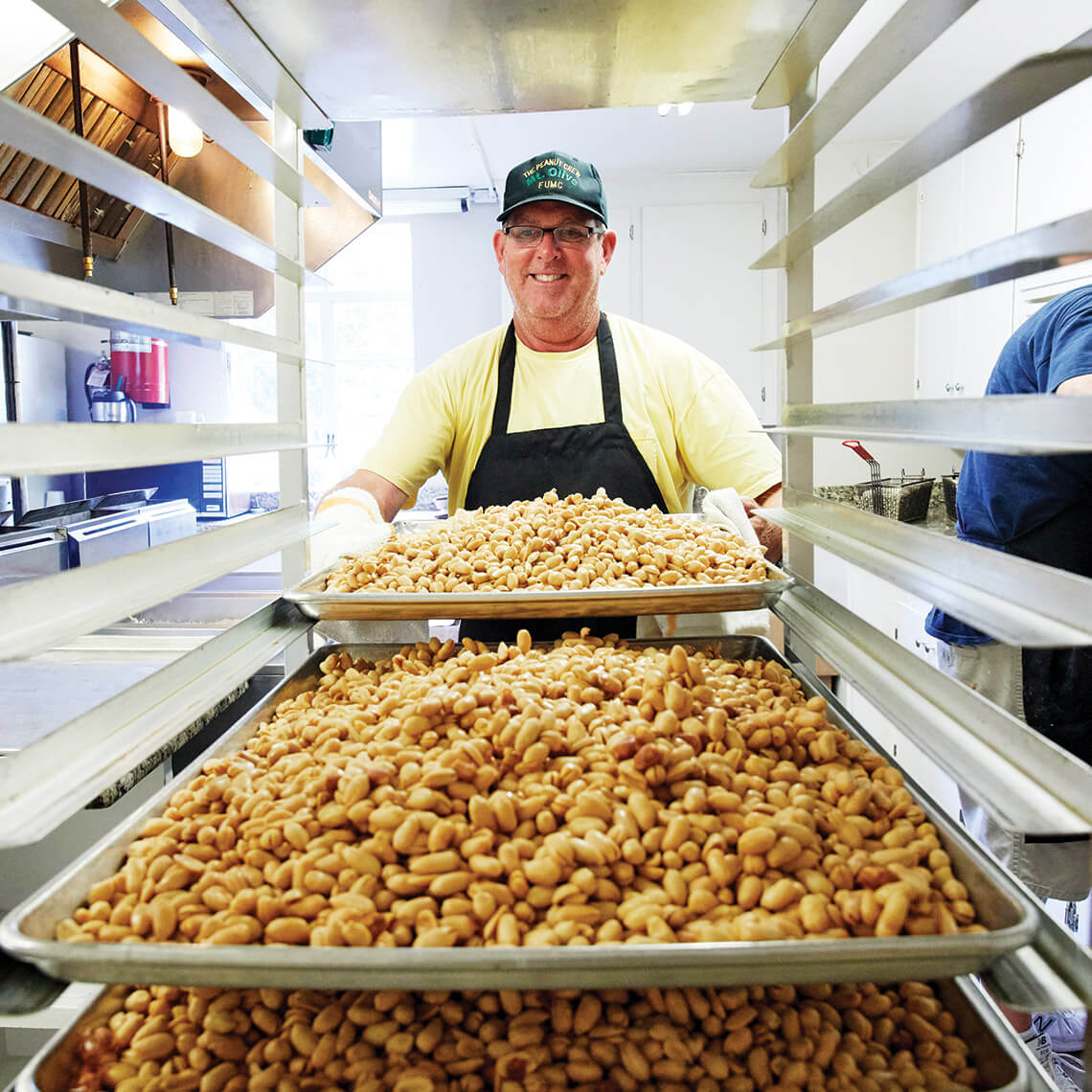 Steve Lane arranges fried peanuts on cooling racks. 