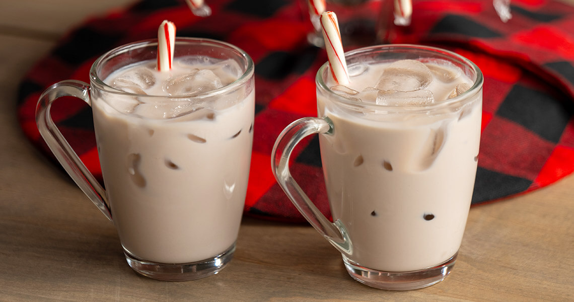 Two cups of Carolina Christmas Punch, garnished with candy canes