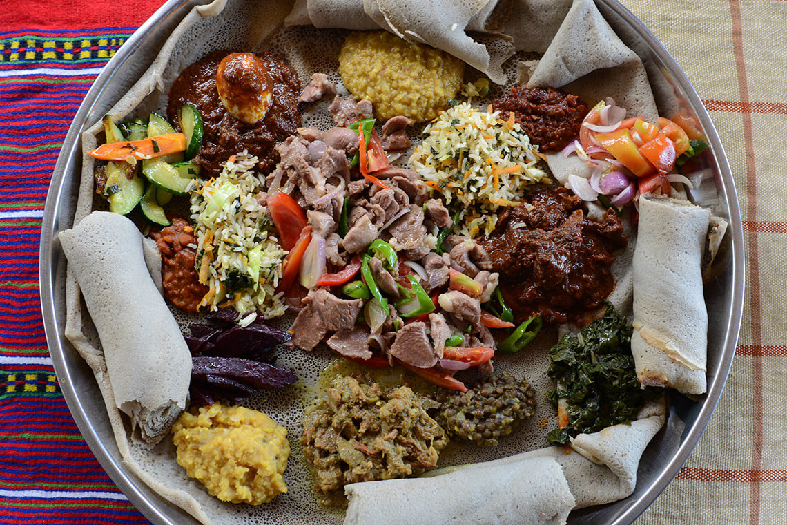 Ethiopian teff topped with various wot, or stewed meats and vegetables.