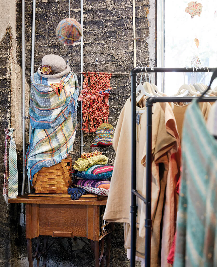 Handmade textile shirts, wraps, and accessories inside the Local Cloth shop in Asheville.