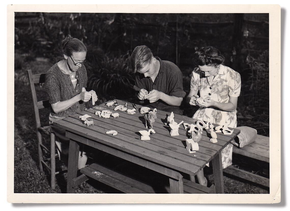 Carvers whittle pieces of wood into figurines