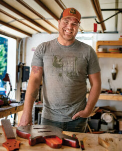 Schiemann with a guitar in his workshop.