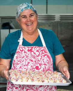 Chris Carroll with a pan of Sweater Box Confections cookies about to go into the oven