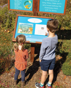 Children follow along the GROW Story Trail that wraps around Lake Tomahawk