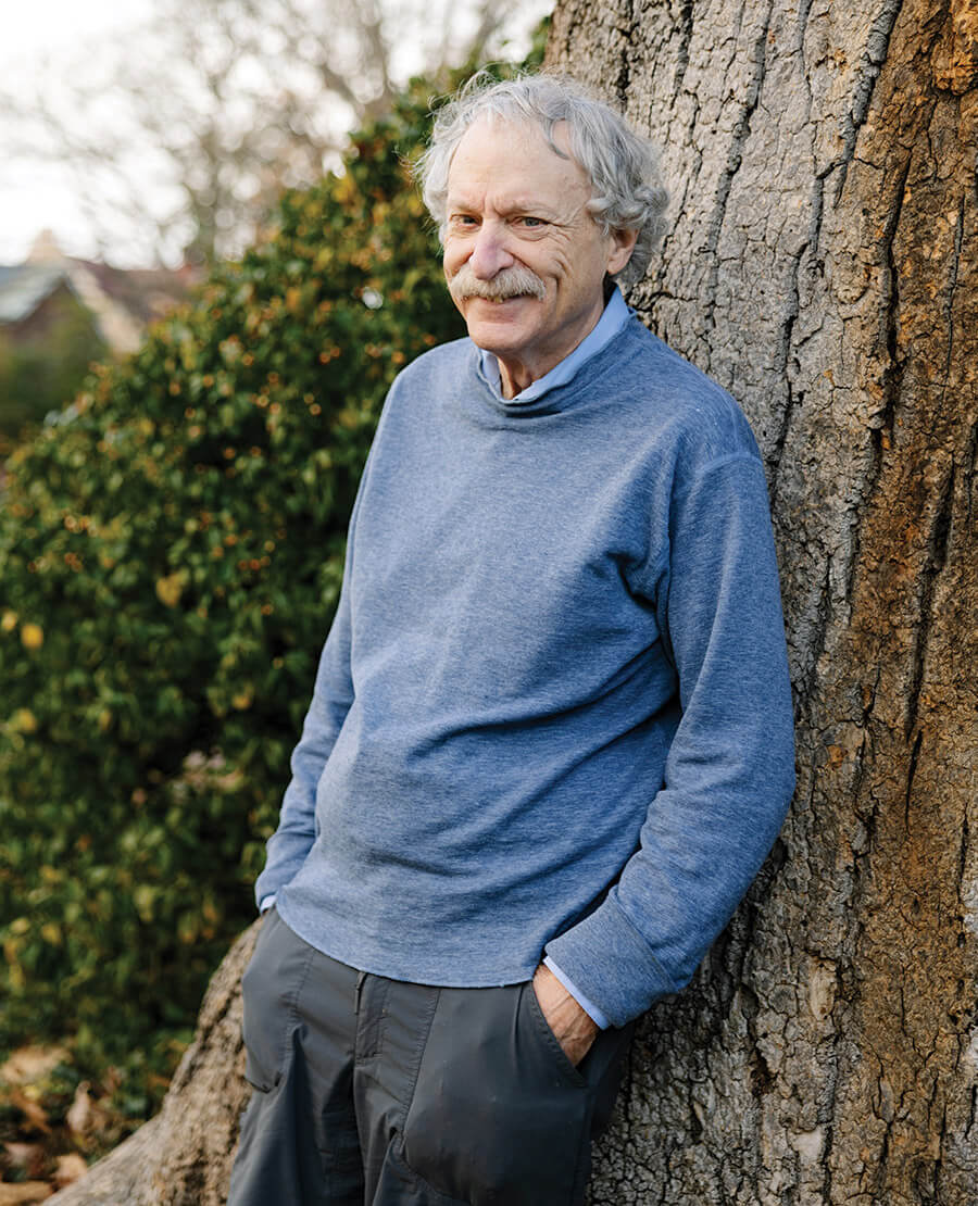 Peter White leans against the Davie Poplar tree on UNC Chapel Hill's campus.