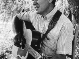 Doc Watson playing his guitar in Deep Gap, NC
