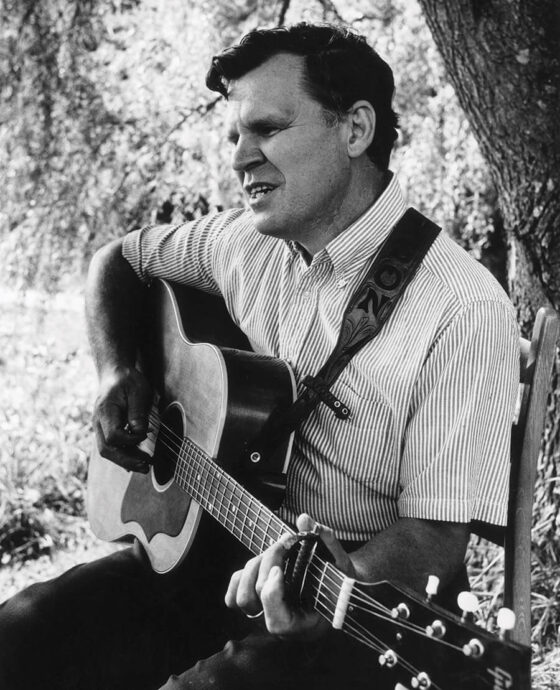 Doc Watson playing his guitar in Deep Gap, NC