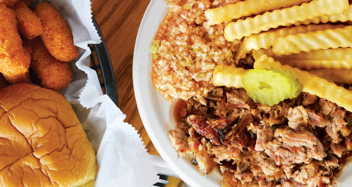 Plate of Lexington-style barbecue, fries, slaw, and hush puppies in Lexington, NC