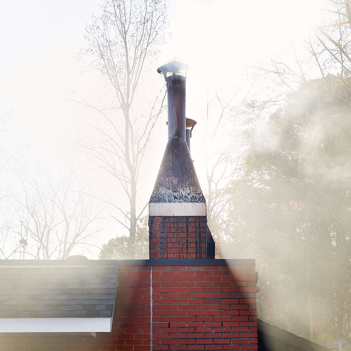 Smoke funnels out of the smokehouse at Lexington Barbece
