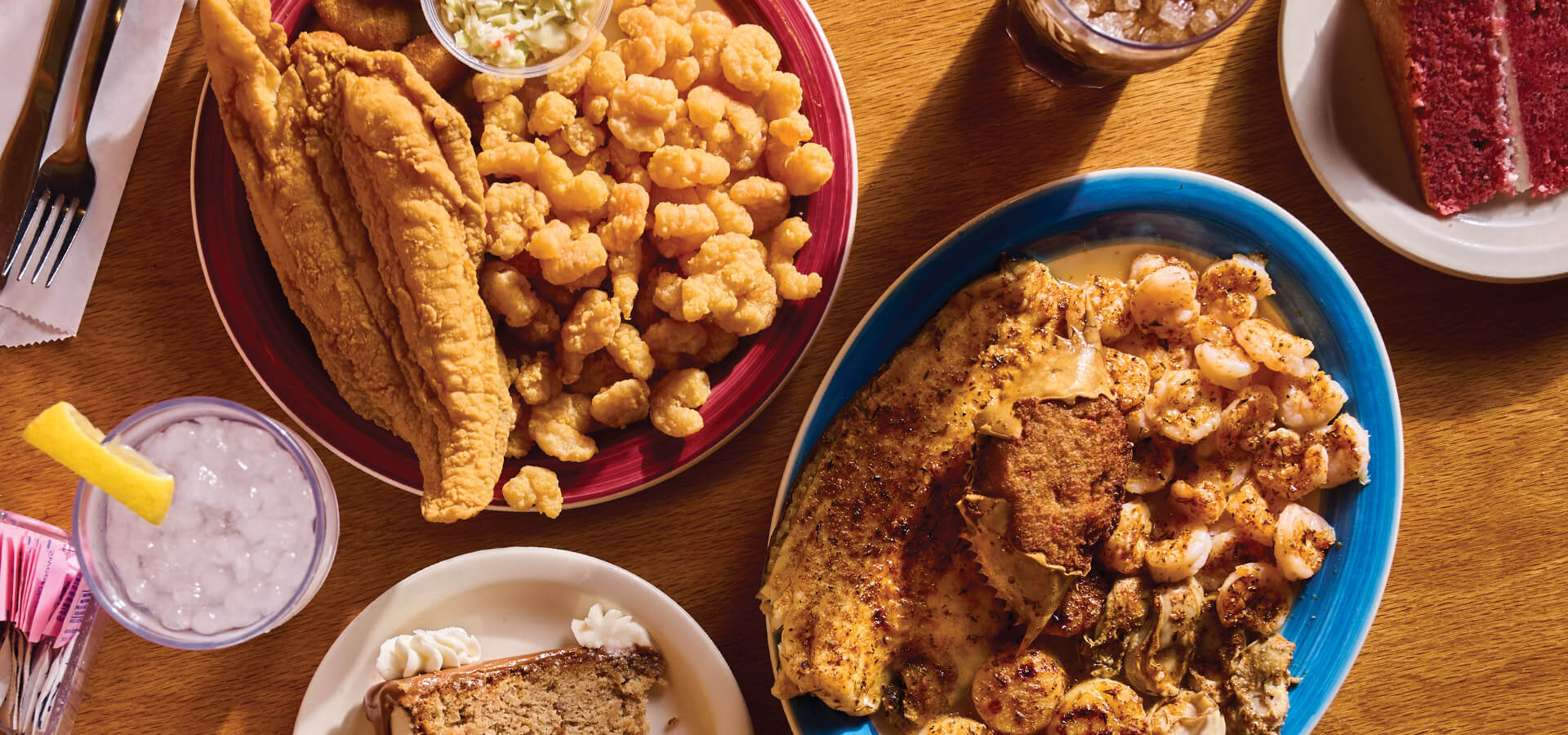 Platters of fried fish and slices of cake on the table at Walkertown Seafood Shack