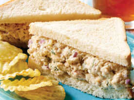 Chicken salad sandwiches on a plate with chips