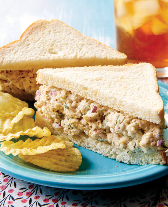 Chicken salad sandwiches on a plate with chips