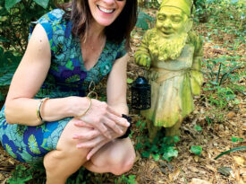 Elizabeth Hudson with a gnome in Elizabethan Gardens.
