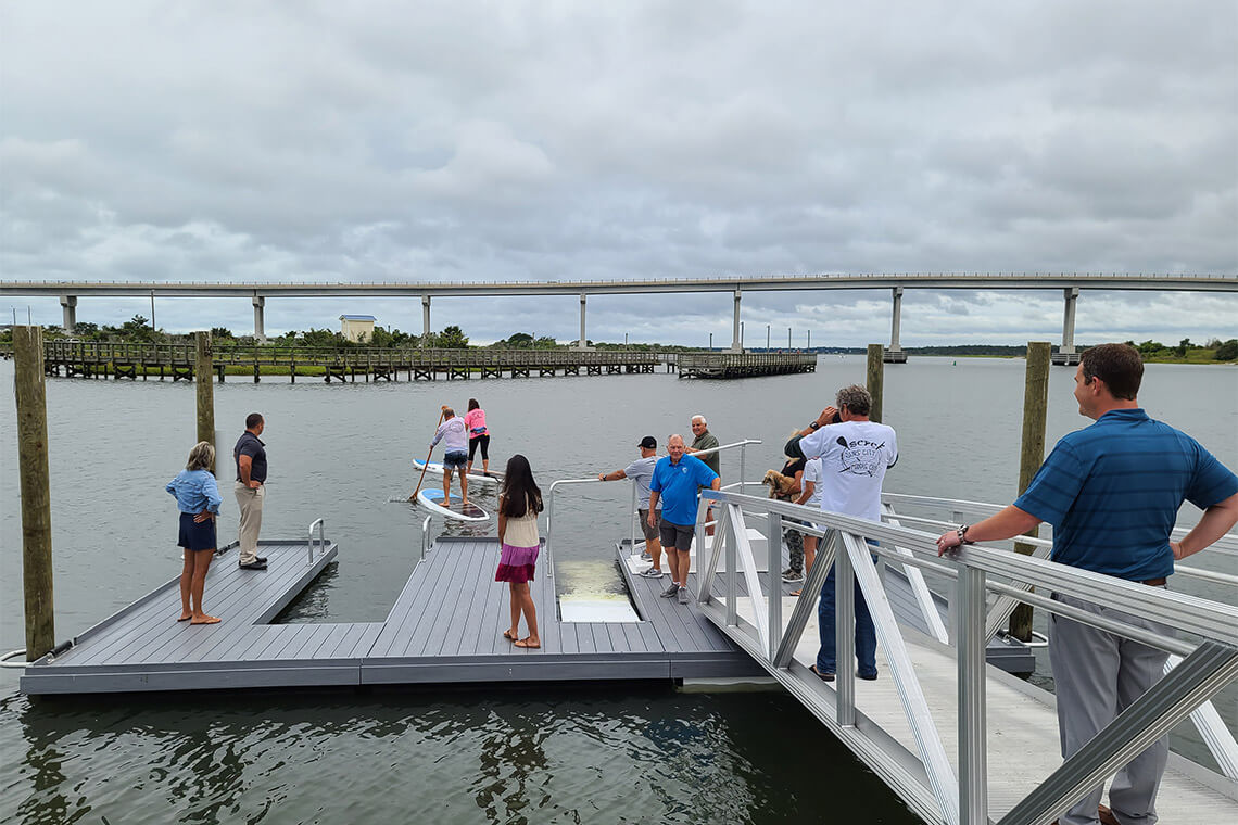 People launch paddleboards into the sound at Soundside Park in Surf City