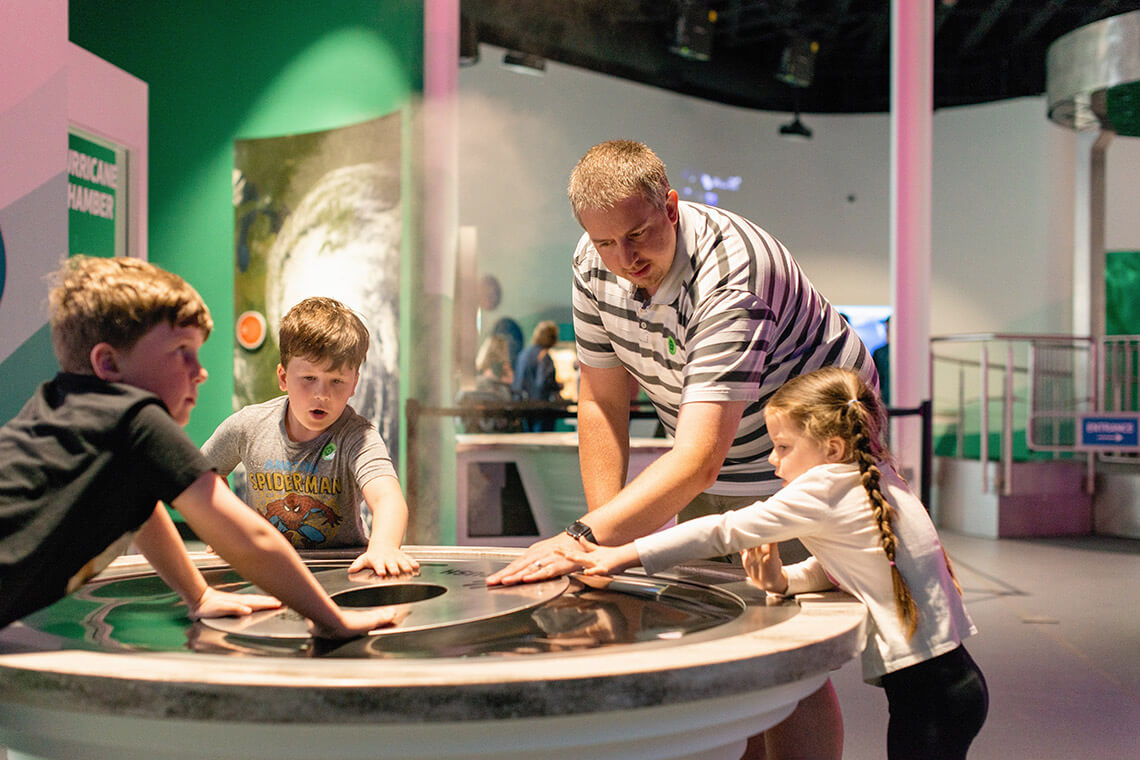 Father and kids learn about gravity at the Danville Science Center.