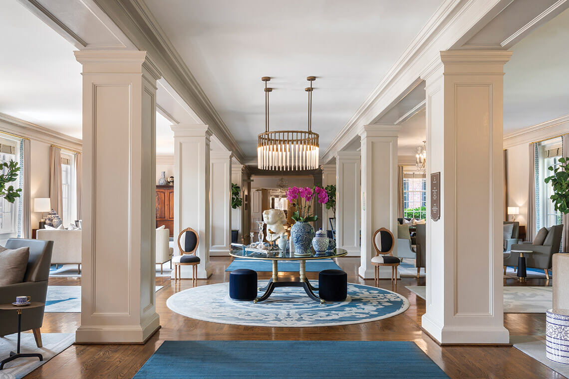 The interior of the Carolina Inn, with columns, lush carpets, fresh flowers, and seating areas. 