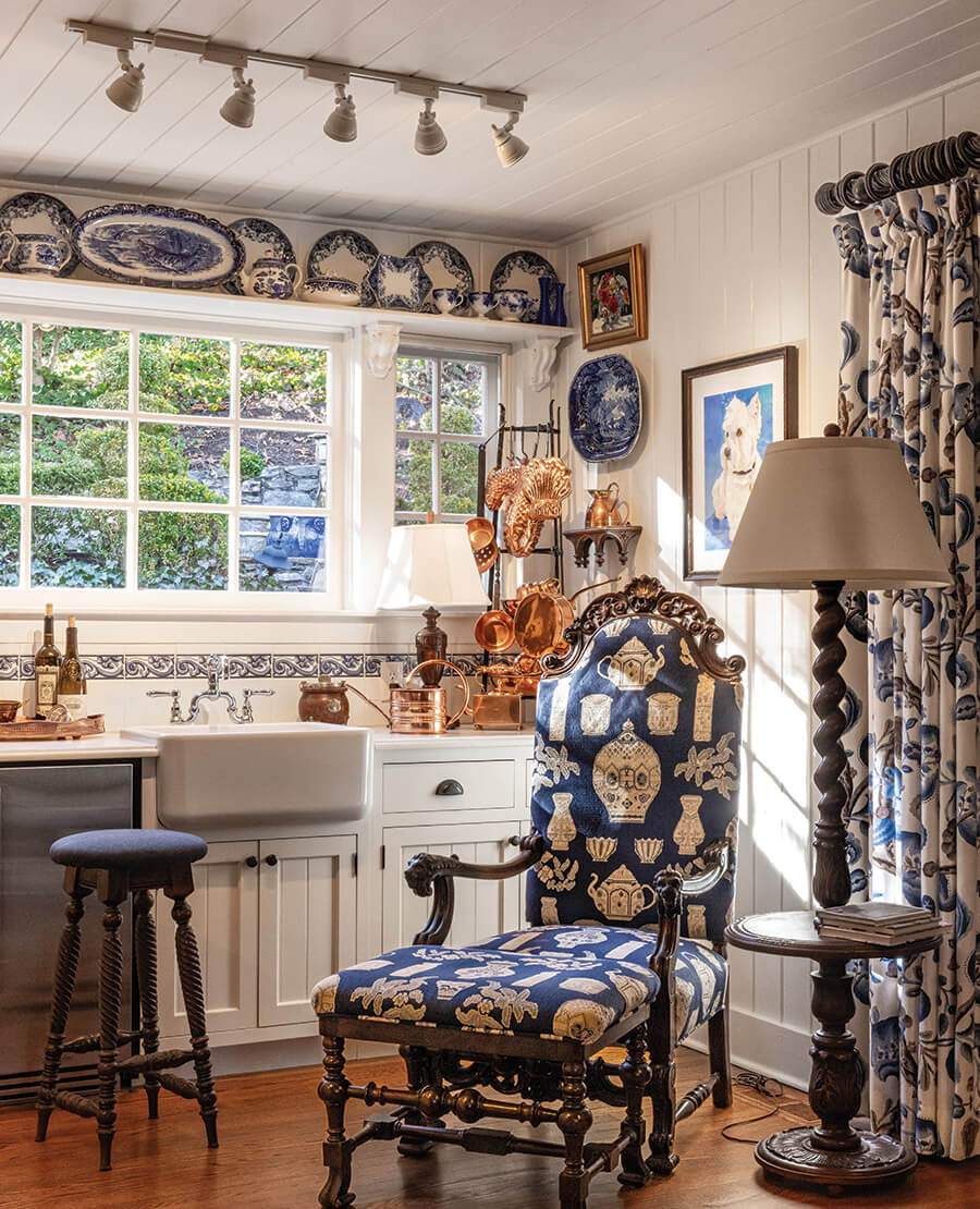 The kitchen in Chestnut Cottage with a blue armchair and blue-and-white china