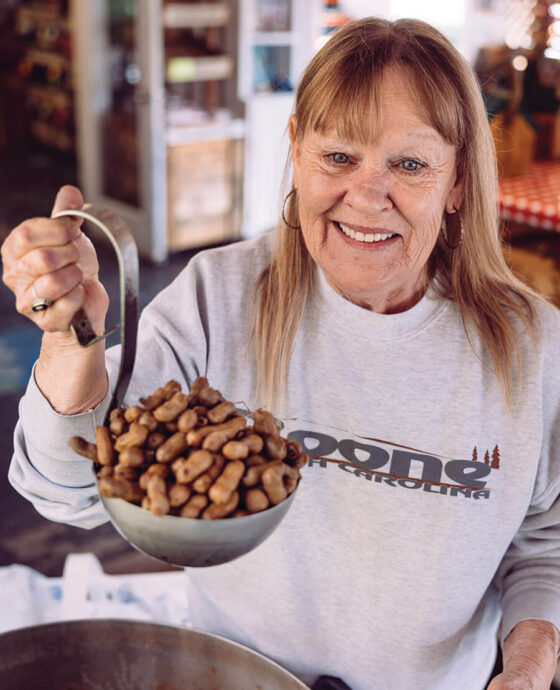 Karen McCard holds up a giant ladle full of boiled peanuts