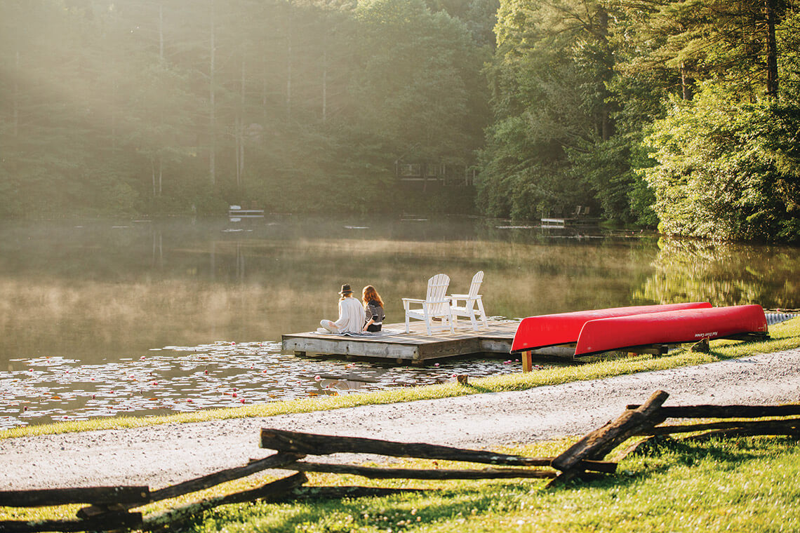 Guests sit at the dock at Apple Lake at Half-Mile Farm