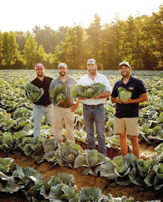 Will Kornegay and his childhood friends Billy McDaniel, Phillip Watson, and Peyton McDaniel holding heads of cabbage at a farm.